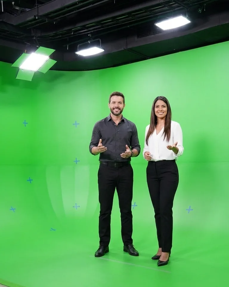 Los dos presentadores sobre el fondo verde